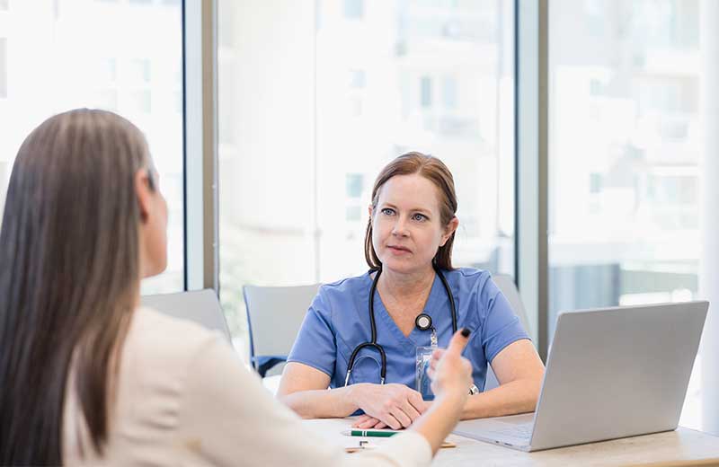 Nurse at table talking with healthcare administrator